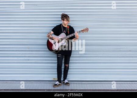 Woodbridge, Suffolk, Royaume-Uni septembre 20 2020: Une femme de 20 quelque chose de relaxant et de jouer une guitare acoustique dehors pour que les passants écoutent aussi Banque D'Images