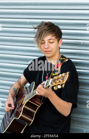 Woodbridge, Suffolk, Royaume-Uni septembre 20 2020: Une femme de 20 quelque chose de relaxant et de jouer une guitare acoustique dehors pour que les passants écoutent aussi Banque D'Images