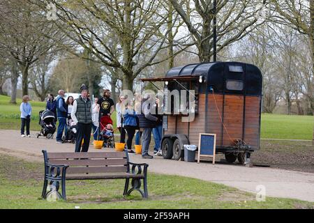 Ashford, Kent, Royaume-Uni. 25 mars 2021. Météo au Royaume-Uni : les gens apprécient le parc Victoria à Ashford, dans le Kent, tandis que les intervalles ensoleillés offrent un agréable soleil de printemps chaud. Les gens font la queue pour prendre un verre ou un en-cas à emporter. Crédit photo : Paul Lawrenson /Alay Live News Banque D'Images