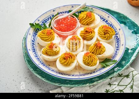 Œufs farcis avec caviar rouge et paprika sur l'assiette pour hors-d'œuvre table de pâques, vue de dessus, espace copie. Plat traditionnel pour des vacances joyeuses Pâques. Banque D'Images