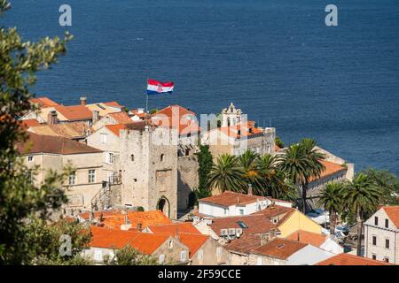 Drapeau croate survolant la porte principale de la ville de Korcula Vieille ville médiévale en Croatie Banque D'Images