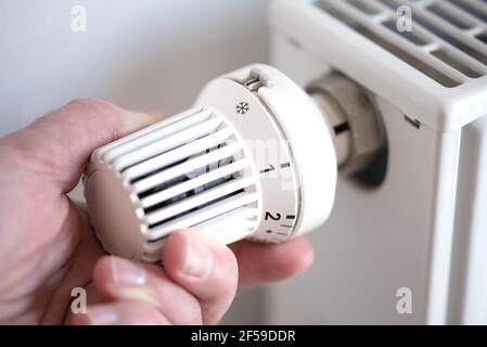 gros plan de la personne qui fait passer le thermostat du radiateur en position anti-gel protection Banque D'Images