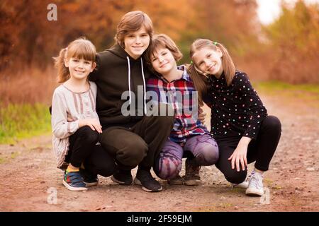 Quatre jeunes filles heureux marchant dans le parc d'automne. Photo de haute qualité Banque D'Images