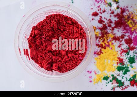 Holi couleurs poudre dispersée sur fond blanc avec Rose ou Gulabi rang à l'avant. Vue de dessus des couleurs holi pour le festival indien de la couleur. Arrière Banque D'Images