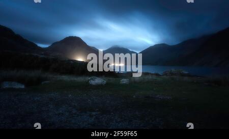 Blue hour à Wasdale, Lake District, Cumbria, UK.paisible paysage de crépuscule avec ciel sombre nuageux sur la vallée de montagne avec lac et voiture lumière Banque D'Images