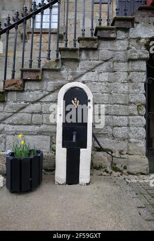 Sanquhar, Dumfries & Galloway, Écosse, Royaume-Uni. 22 mars 2021. Péage à l'extrémité nord de la grande rue. Une ancienne pompe à eau à côté du bâtiment Banque D'Images