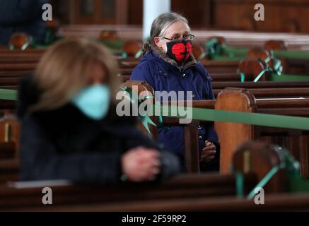 Un paroishioner siège comme Canon Tom White est un service de masse à St. Mary's Catholic Chuch à Calton, Glasgow, après que les règlements du coronavirus qui ont forcé la fermeture des églises en Écosse et criminalisé le culte public ont été jugés illégaux par la Cour de session. Les églises doivent être autorisées à s'ouvrir vendredi sous la direction du gouvernement écossais. Date de la photo: Jeudi 25 mars 2021. Banque D'Images