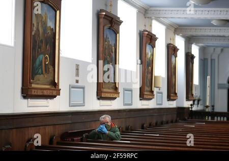 Un paroishioner siège comme Canon Tom White est un service de masse à St. Mary's Catholic Chuch à Calton, Glasgow, après que les règlements du coronavirus qui ont forcé la fermeture des églises en Écosse et criminalisé le culte public ont été jugés illégaux par la Cour de session. Les églises doivent être autorisées à s'ouvrir vendredi sous la direction du gouvernement écossais. Date de la photo: Jeudi 25 mars 2021. Banque D'Images