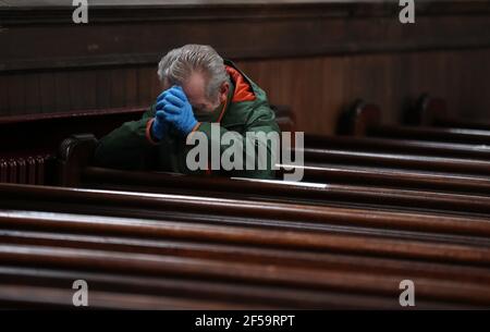 Un paroishioner siège comme Canon Tom White est un service de masse à St. Mary's Catholic Chuch à Calton, Glasgow, après que les règlements du coronavirus qui ont forcé la fermeture des églises en Écosse et criminalisé le culte public ont été jugés illégaux par la Cour de session. Les églises doivent être autorisées à s'ouvrir vendredi sous la direction du gouvernement écossais. Date de la photo: Jeudi 25 mars 2021. Banque D'Images