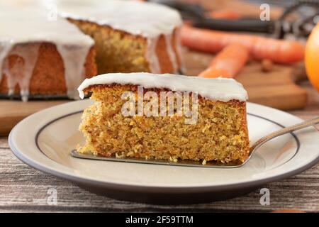 Morceau de gâteau frais de carotte avec glaçage au citron sur une assiette avec un serveur à gâteau Banque D'Images