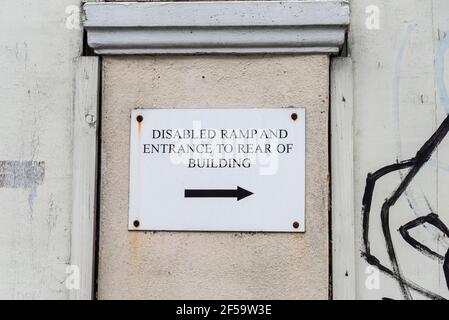 Rampe d'accès pour handicapés et entrée à l'arrière du panneau du bâtiment, sur le bâtiment en décomposition de Westcliff on Sea, Southend. Accès pour personnes handicapées. Séparer Banque D'Images