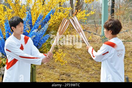 Naraha, Japon. 25 mars 2021. Azusa Iwashimizu (R), membre de l'équipe nationale japonaise de football féminin a remporté la coupe du monde des femmes de football 2011 en Allemagne, passe la flamme olympique à l'élève du lycée Asato Owada à un point de baiser lors du grand départ du relais de la torche au centre national d'entraînement de J-Village à Naraha, préfecture de Fukushima, Japon le jeudi 25 mars 2021. Photo par Keizo Mori/UPI crédit: UPI/Alay Live News Banque D'Images