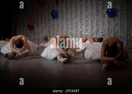 Ballerinas sont dans une rangée. Les filles sont alignées l'une après l'autre sur la scène. Ballerinas en blanc tutus ont leur dos à la caméra. Filles perf Banque D'Images