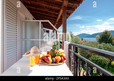 Gros plan de terrasse ouverte balcon sous le vieux toit en chêne de style moderne chambre d'hôtel appartement avec jardin d'été, mer bleue, vue panoramique sur la montagne Banque D'Images