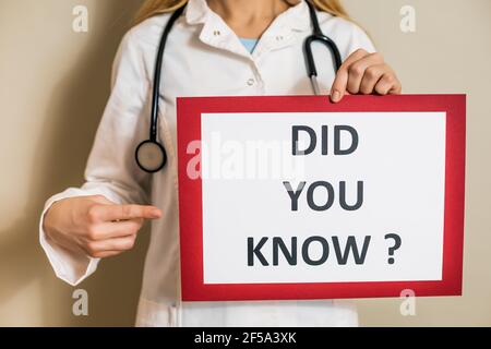 Image d'une femme médecin tenant un papier avec un texte le saviez-vous. Banque D'Images