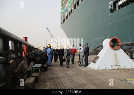 (210325) -- LE CAIRE, le 25 mars 2021 (Xinhua) -- des fonctionnaires de l'Autorité du canal de Suez travaillent sur le site d'un navire à conteneurs piégé sur le canal de Suez en Égypte le 25 mars 2021. La navigation dans le canal de Suez a été suspendue temporairement jusqu'à la fin des travaux de re-flottaison sur un navire ancré dans un nouveau cours, a déclaré jeudi Oussama Rabie, président de l'Autorité du canal de Suez (SCA). Le navire à conteneurs portant le drapeau du Panama, d'une capacité de 224,000 tonnes, a été mis à la terre tôt mardi dans le nouveau passage après avoir perdu la capacité de conduire dans des vents violents et une tempête de poussière, a déclaré l'ACR mercredi dans une déclaration. (S Banque D'Images