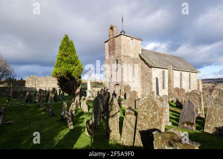 Église Saint-Cuthberts avec sa croix anglo-saxonne du VIIe siècle dans le cimetière et le château médiéval adjacent à Bewcastle, Cumbria UK Banque D'Images