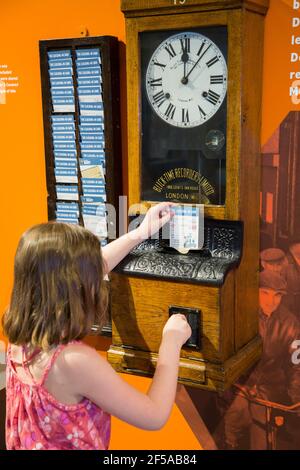 Enfant visiteur fille touriste opérant un pointage dans la machine à l'horloge à l'exposition de vapeur, acier et sous-marins à l'historique Dockyard / Dockyards Chatham dans le Kent. ROYAUME-UNI (121) Banque D'Images