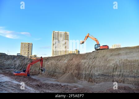 Creuser la base de la fosse un trou avec la pelle hydraulique. Des travaux de terrassement dans l'excavation et le remblayage du sol jusqu'à la profondeur requise sont nécessaires pour la construction de Banque D'Images