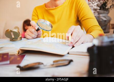 Femme planifiant une visite avec plan de voyage à la maison - maman recherche de nouveaux pays à explorer avec sa famille - Concept d'ouverture et de liberté après Covid 19 TI Banque D'Images