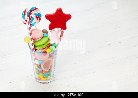 Assortiment de bonbons divers. Bonbons, bonbon, chocolat et macarons en verre à cocktail sur fond de bois. Avec espace de copie Banque D'Images