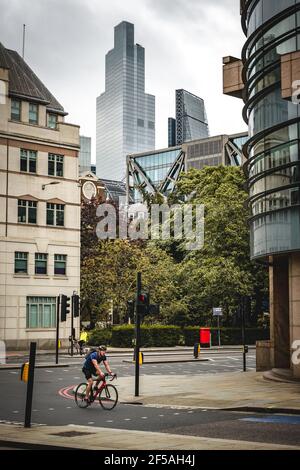 Homme à vélo à travers une jonction à Londres, Angleterre, Royaume-Uni Banque D'Images