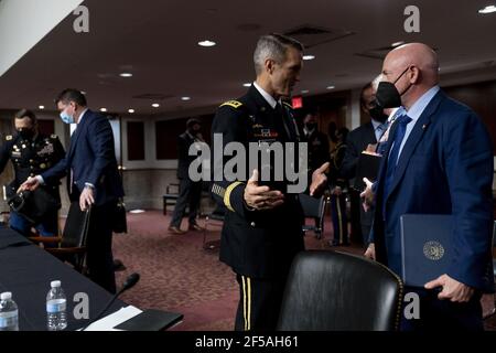 Général de commandement des opérations spéciales Richard Clarke, à gauche, Et le sénateur Mark Kelly, D-Ariz., à droite, prennent la parole à la suite d'une audience visant à examiner le Commandement des opérations spéciales des États-Unis et le Cyber Commandement des États-Unis dans le cadre de l'examen de la demande d'autorisation de défense pour l'exercice 2022 et le Programme de défense des années futures, à Capitol Hill, le jeudi 25 mars 2021, À Washington. On trouve également sur la photo le secrétaire adjoint par intérim à la Défense pour les opérations spéciales et les conflits de faible intensité Christopher Maier, deuxième de gauche. Photo de piscine par Andrew Harnik/UPI Banque D'Images