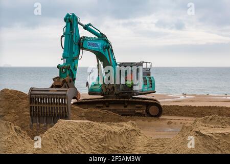 Pelle excavatrice Ovenden SK500 excavateur déplacement du sable sur la plage pour des travaux de réapprovisionnement de plage à Bournemouth et Poole Beaches, Dorset UK en mars Banque D'Images