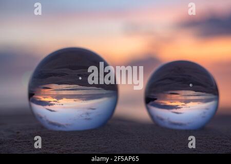 Trois boules de cristal claires de trois tailles sont sphérique révèle vue paysage avec sphérique placé sur le sable à Karon Beach pendant le coucher du soleil. Banque D'Images