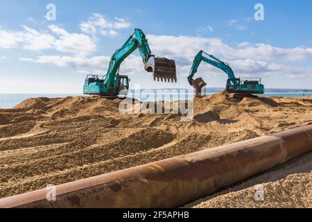 Les excavateurs Ovenden SK500 déplacent du sable sur la plage pour des travaux de réapprovisionnement de plage à Bournemouth et Poole Beaches, Dorset UK en mars Banque D'Images