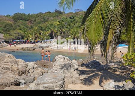 Touristes à la crique abritée avec plage de sable près de Puerto Escondido, San Pedro Mixtepec, Oaxaca, Mexique Banque D'Images