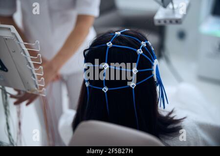 Patiente dans un capuchon en silicone en cours de procédure EEG Banque D'Images