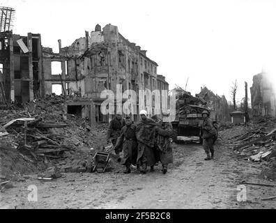 Cologne, Allemagne 1945 soldats américains escortés blessés ont capturé des soldats allemands après qu'ils se sont rendus pendant la Seconde Guerre mondiale à la suite d'un violent bombardement de la ville. Seconde guerre mondiale : défaite allemande victoire alliée Deutschland les années 1940 rendent l'Europe la destruction de l'histoire européenne Banque D'Images