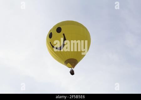 un ballon d'air chaud jaune avec un sourire riant est voler dans l'air Banque D'Images