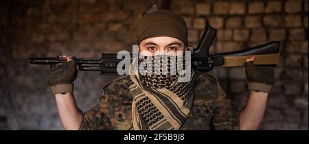 Soldat arabe dans un headaddress du keffiyeh national avec des armes dans ses mains. Musulman avec armes à feu Banque D'Images