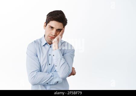 Employé de bureau fatigué grincheux, regardant avec le visage en colère et les cercles sombres sous les yeux, fatigué de travailler, penché sur la paume avec le visage de fatigue endormi Banque D'Images