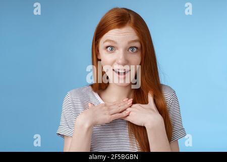 Étonné surpris jeune fille sincère redhead look étonné questionné gasting paumes de la presse impressionnées poitrine yeux larges stupéfaits recevoir agréable Banque D'Images