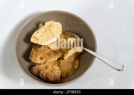 Gâteau traditionnel aux pommes britannique servi dans un bol arrière-plan blanc Banque D'Images