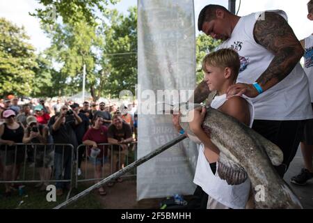 Un nouiller triomphant expose fièrement son poisson-chat à une foule enthousiaste lors du tournoi annuel Okie Noodling à Paul's Valley, Oklahoma. Banque D'Images