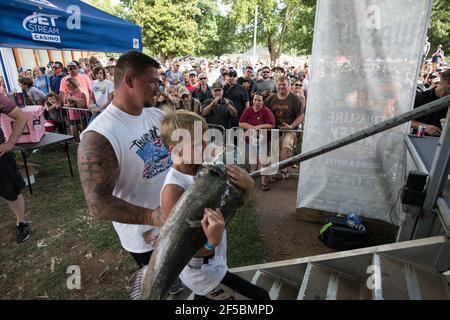 Un nouiller triomphant expose fièrement son poisson-chat à une foule enthousiaste lors du tournoi annuel Okie Noodling à Paul's Valley, Oklahoma. Banque D'Images