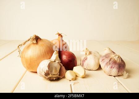 variation de différents oignons communs, rouges et à l'ail sur une table en bois blanc Banque D'Images