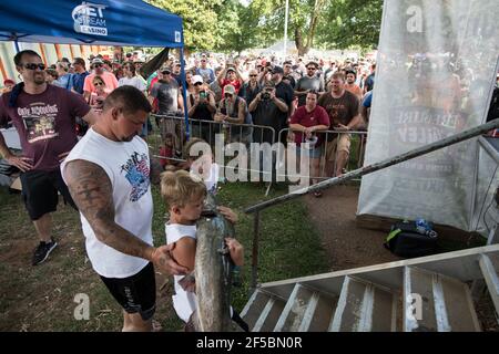 Un nouiller triomphant expose fièrement son poisson-chat à une foule enthousiaste lors du tournoi annuel Okie Noodling à Paul's Valley, Oklahoma. Banque D'Images