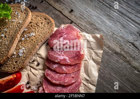 Cuisine rurale sur une table vintage. En tranches sur une planche. Légumes, pain et viande sur la table. Composants d'un sandwich. Banque D'Images