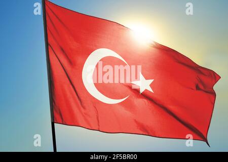 Drapeau turc agitant sur le vent devant le soleil Banque D'Images