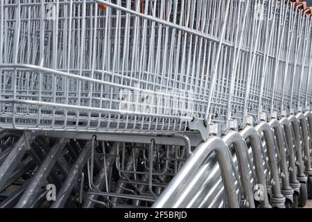 Une rangée de chariots de chaîne de supermarchés vides poussés ensemble Banque D'Images