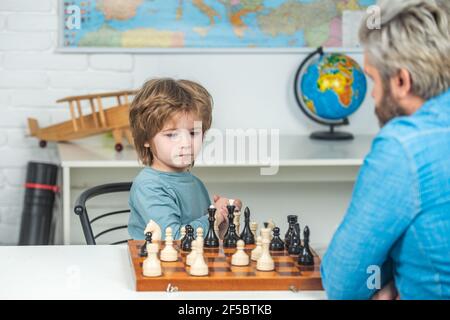 Jeux et activités pour les enfants. Concept de famille. Développement précoce des enfants. Garçon pense ou plan au jeu d'échecs, style vintage pour le concept d'éducation. Banque D'Images