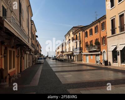 Bardolino, Italie. 25 mars 2021. Vue le long de la Piazza Giacomo Matteotti rue principale dans la ville de Bardolino à midi, au lac de Garde, ni-eux Italie. Bardolino est célèbre pour la culture du vin rouge homonyme connu dans le monde entier avec un patrimoine historique dont les murs anciens, les nombreuses églises et villas de l'époque vénitienne témoignent. Chaque année, un millier de touristes arrivent au printemps, aujourd'hui le cinquième jour du printemps. Ses rues sont vides, pendant la troisième vague de l'épidémie de Covid-19. Le nouveau Lockdown a commencé il y a 17 jours (8 mars) en Italie. Credit: ALEJANDRO SALA/Alamy Live News Banque D'Images