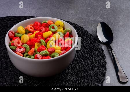 Petit déjeuner avec des anneaux de fruits servi dans un bol avec du lait. Banque D'Images