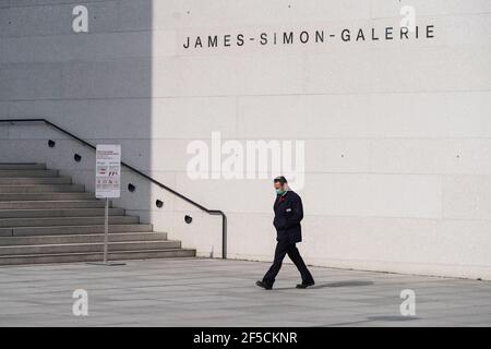 Berlin, Allemagne. 25 mars 2021. Un membre du personnel passe devant la galerie James Simon à Berlin, capitale de l'Allemagne, le 25 mars 2021. Les infections quotidiennes par COVID-19 en Allemagne ont fortement augmenté avec l'enregistrement de 22,657 nouveaux cas en une journée, environ 5,100 il y a plus d'une semaine, a déclaré jeudi l'Institut Robert Koch (RKI). Le taux d'incidence de la COVID-19 sur sept jours dans le pays est également passé de 108.1 pour 100,000 000 personnes la veille à 113.3 jeudi, selon l'agence fédérale de contrôle et de prévention des maladies. Credit: Stefan Zeitz/Xinhua/Alay Live News Banque D'Images