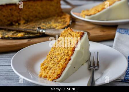 Morceau de gâteau de carotte sur une assiette avec fourchette sur fond de table de cuisine. Vue avant Banque D'Images